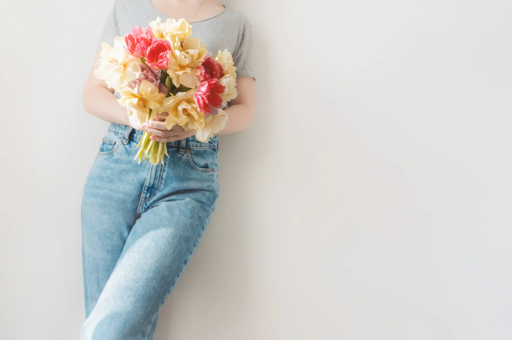 Frau in Jeans mit Tulpenstrauss