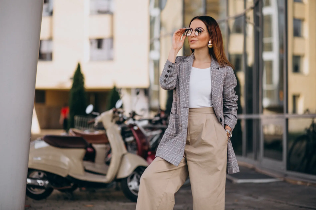 Selbstbewusste Frau im Blazer und mit Sonnenbrille