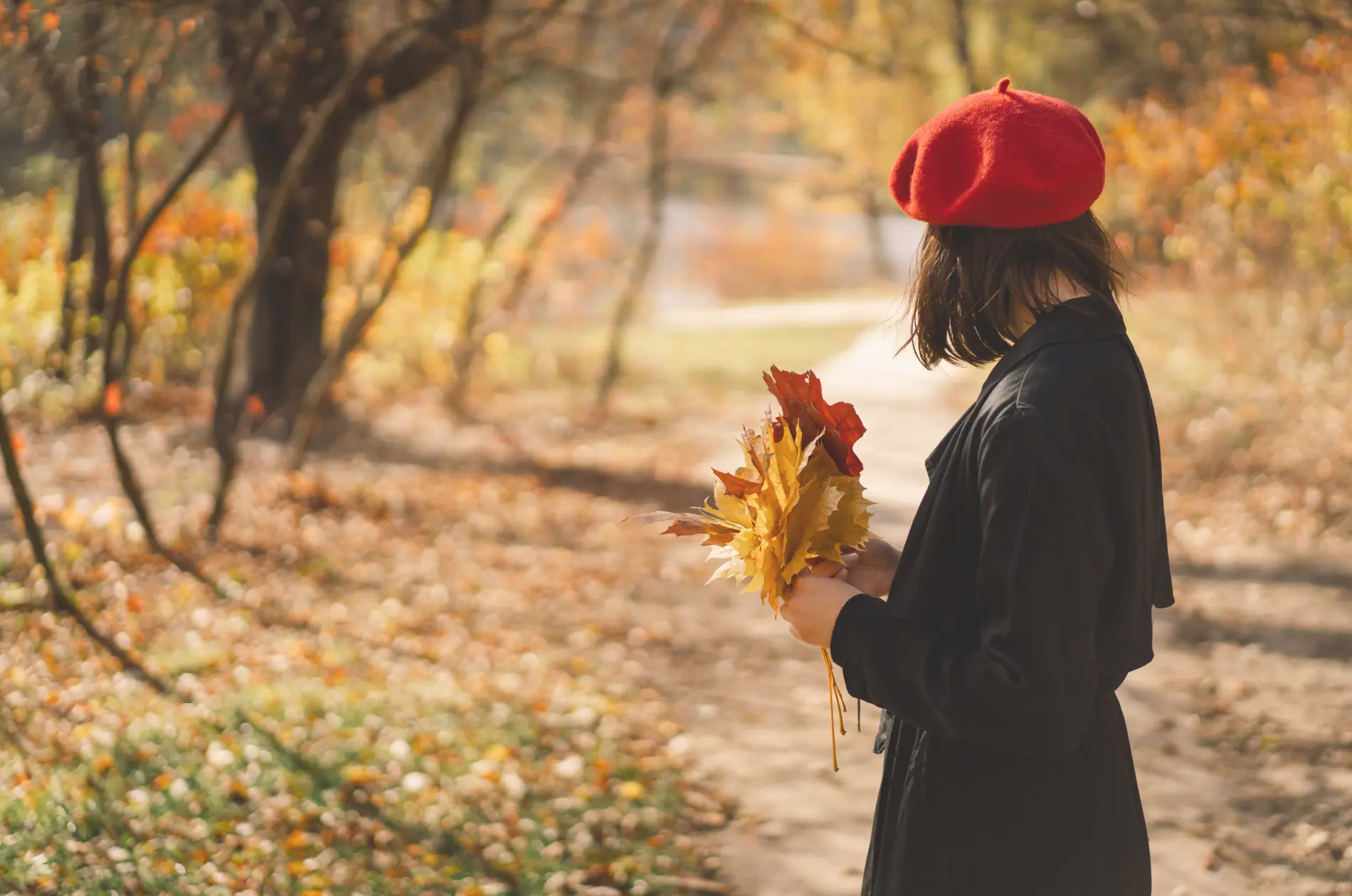 Frau mit rotem Barett im Herbstwald
